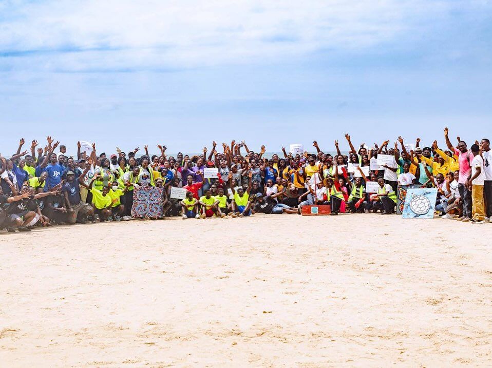 Large group of volunteers gathered on the beach for a clean-up
