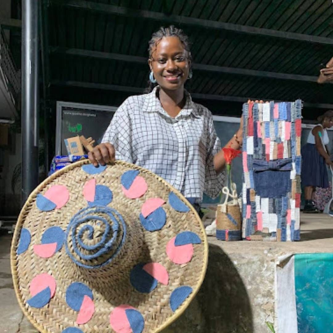 Woman holding a colourful hat and bags made from upcycled materials